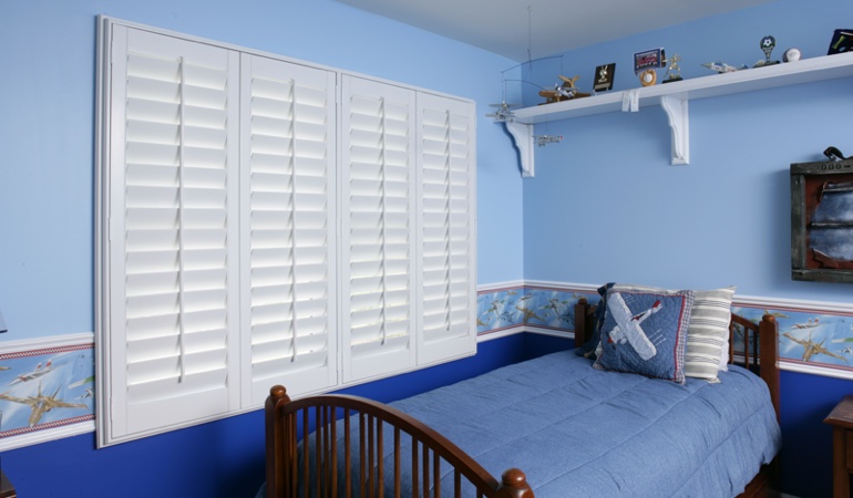 White plantation shutters in blue kids bedroom in San Antonio 